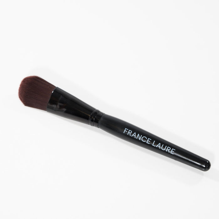 France Laure makeup brush with black handle and dense brown bristles, ideal for flawless cosmetic application on all skin types.