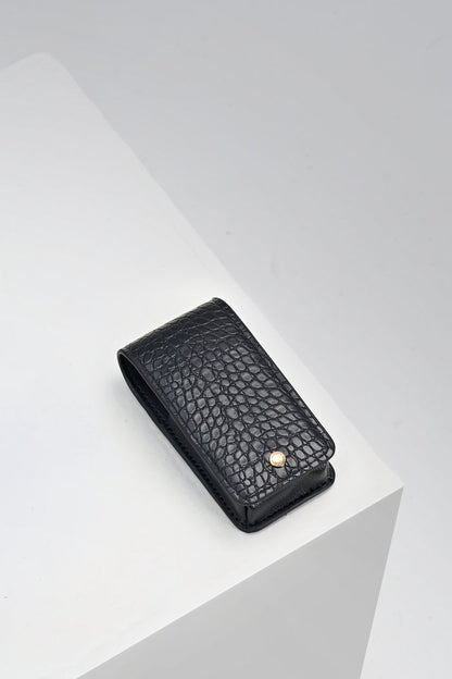 Aisling Black crocodile print faux leather Lipstick Holder with gold mag dot closure detail on the front displayed on a white plinth