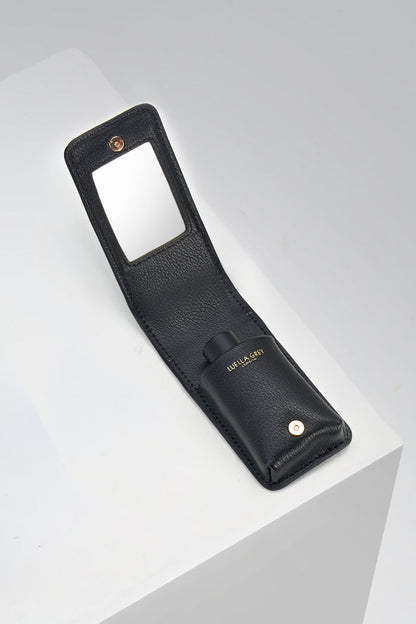 Inside of Aisling Black crocodile print faux leather Lipstick Holder showing a pocket for lipsticks and a mirror on the flap displayed on a white plinth