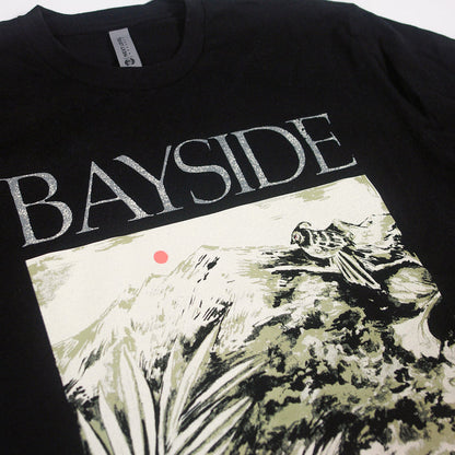 A black Bayside t-shirt displays BAYSIDE in bold white letters with a bird on rocks, mountains, plants, and a red sun—a unique design available only here.