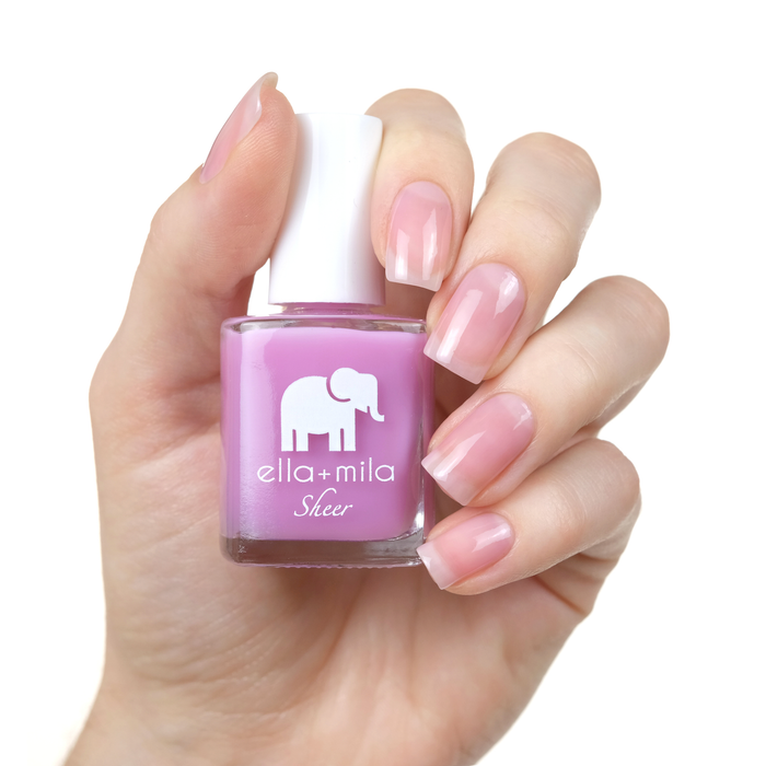 Bold sheer pink lavender tint nail polish manicure on a light skin tone with the bottle