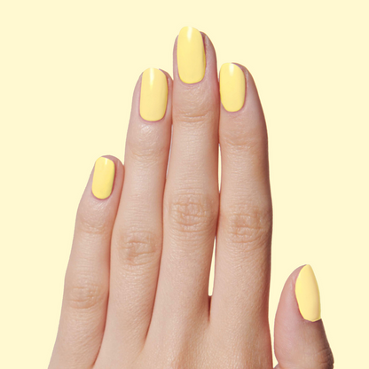 Hand with nails painted in Bright & Focused yellow for a cheerful, creative at-home gel polish manicure look