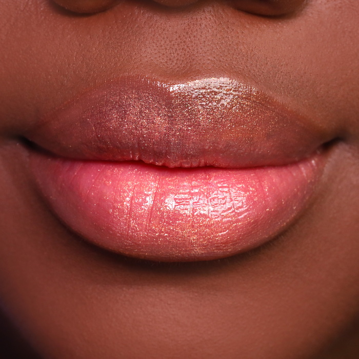 Bronze Babe bronze shimmer lip gloss on lips, medium-deep skin tone