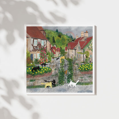 Unframed art print of cats in a colorful village garden courtyard
