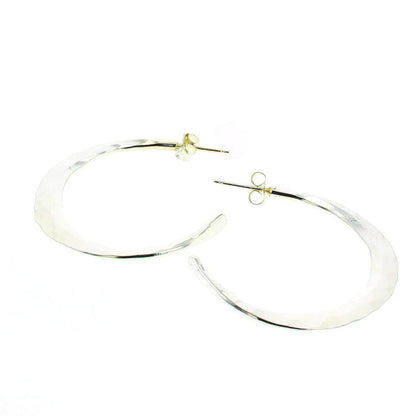 Silver statement hoop earrings with smooth, reflective oval shape