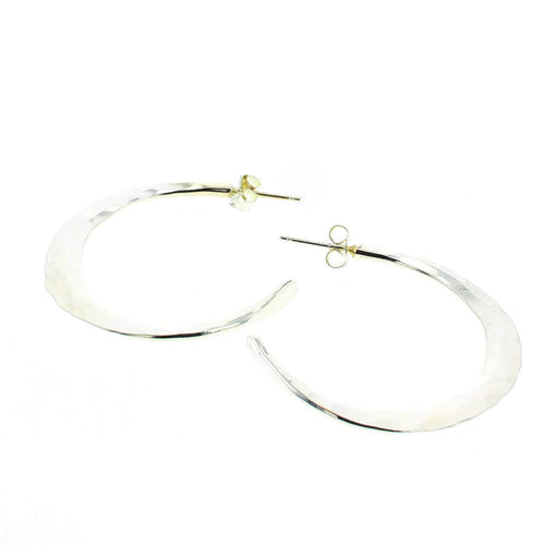 Silver statement hoop earrings with smooth, reflective oval shape