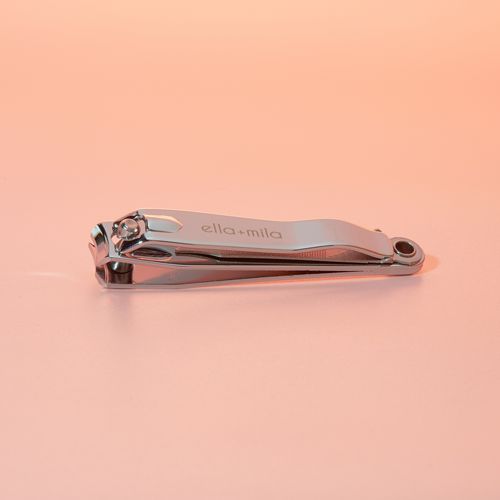 Stainless steel nail clipper on a peach background