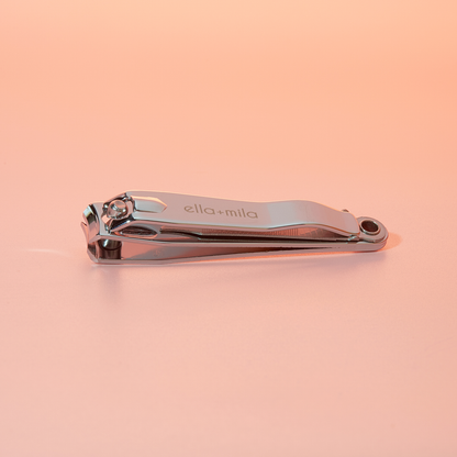 Stainless steel nail clipper on a peach background