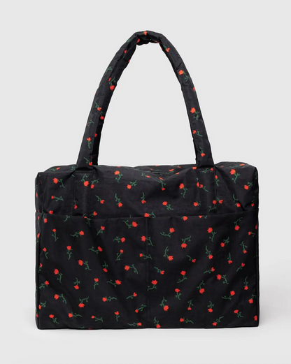 Carry-on travel bag with black base and small red cherry print, short top handles.