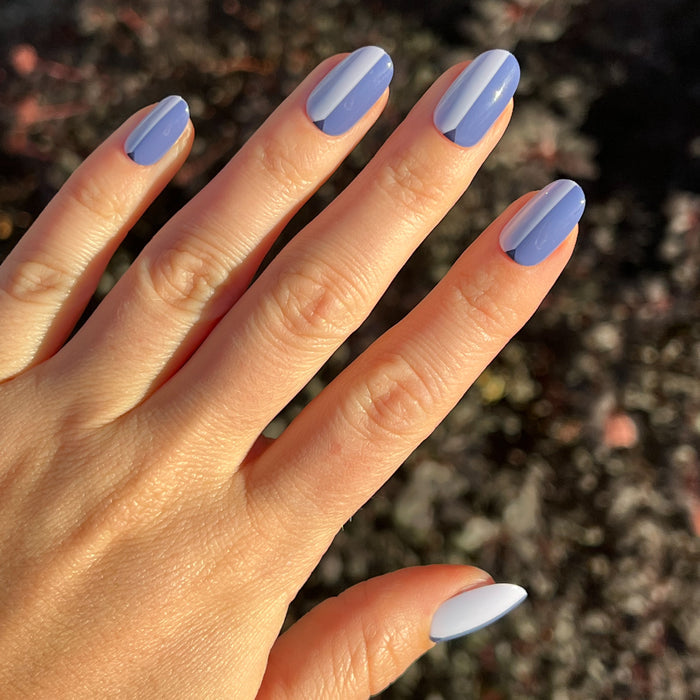 Colorblock Triangle - Press-On | Medium | Oval showing hand with medium oval blue press-on nails featuring triangle accents in natural light