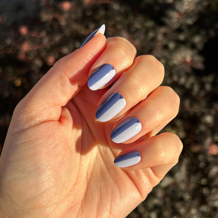 Colorblock Triangle - Press-On | Medium | Oval showing medium oval press-on nails with blue and pale blue colorblock manicure on hand