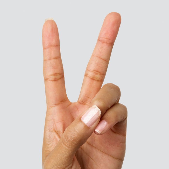 Hand making a peace sign with nails polished in COSMIC clear shimmer for a subtle at-home mani shine