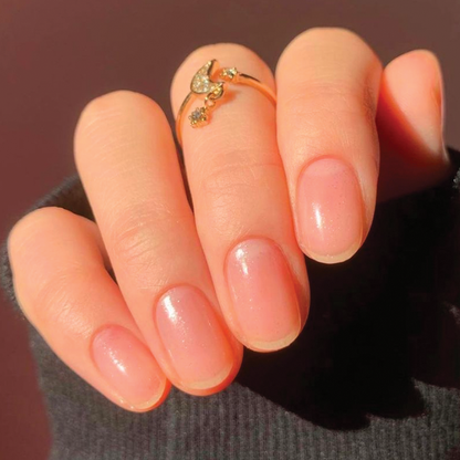 Close-up of natural nails with a gentle shine from COSMIC clear polish for a subtle manicure with shimmer effect