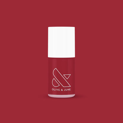 Bottle of Olive and June Cozy Up nail polish in warm brick red for mani and at-home manicure looks