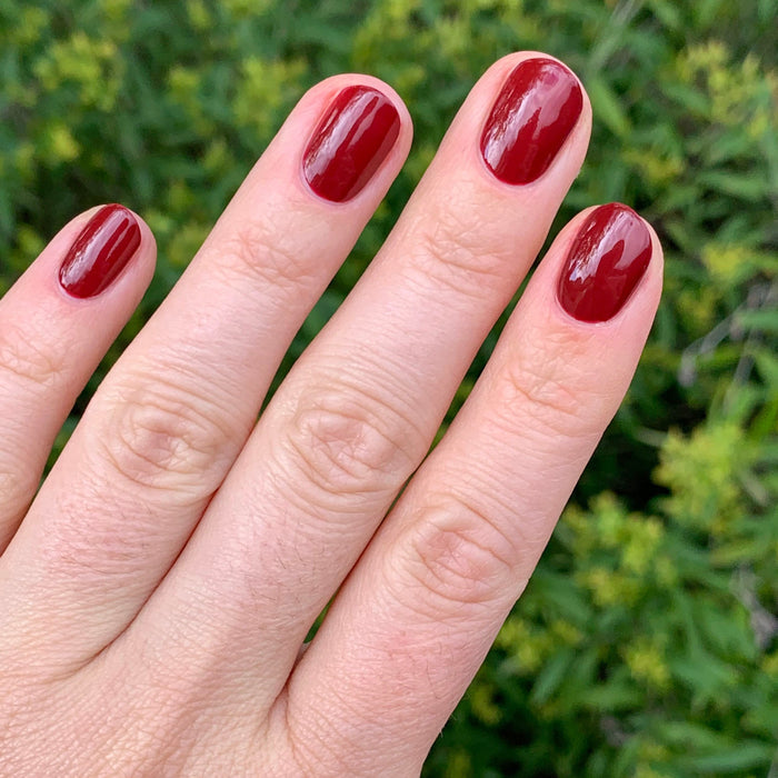 Fingers with shiny nails painted in Olive and June Cozy Up polish for a warm and polished mani look at home