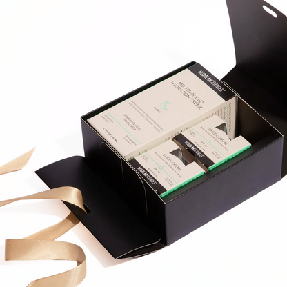 Black gift box with skincare products and a gold ribbon on a white background
