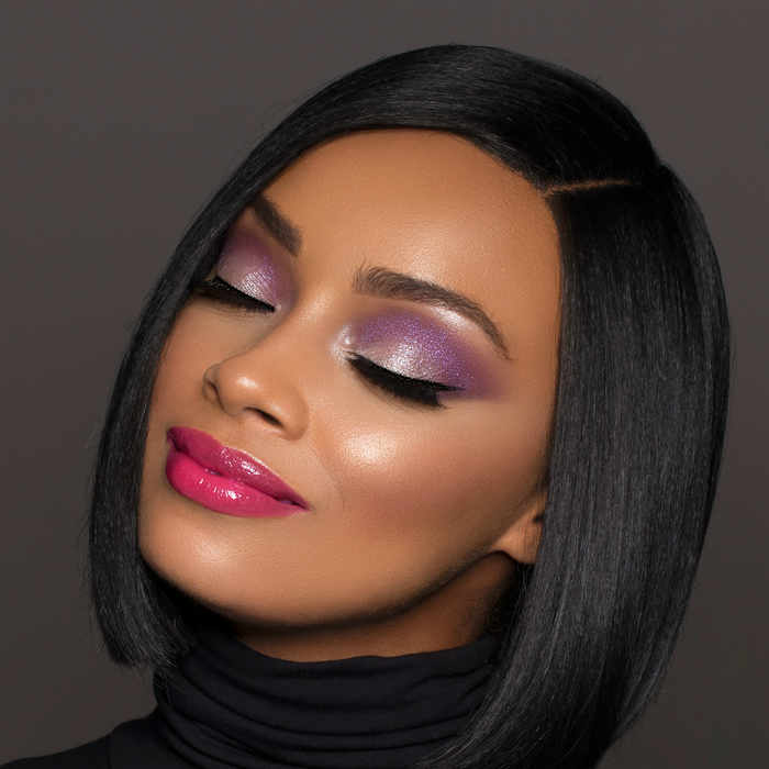 Model wearing Dream Up magenta lipstick with purple eyeshadow and a sleek bob
