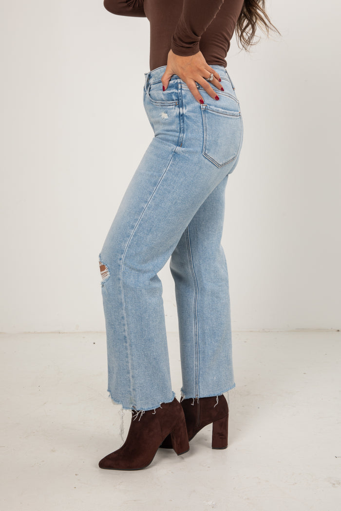 Light blue jeans worn by a person on a white background