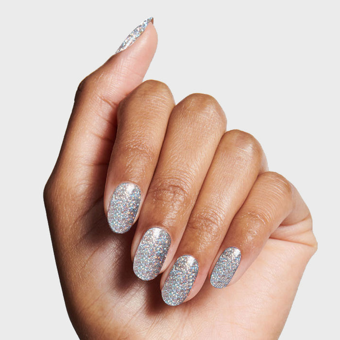 Hand showing nails painted with Exclamation Point silver holographic glitter polish for a sparkling at-home mani
