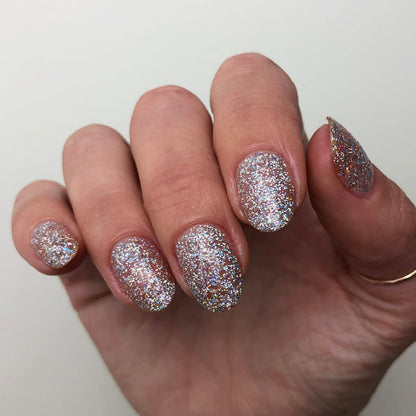 Fingernails coated in Exclamation Point silver holographic glitter polish for a dazzling and long-lasting at-home manicure