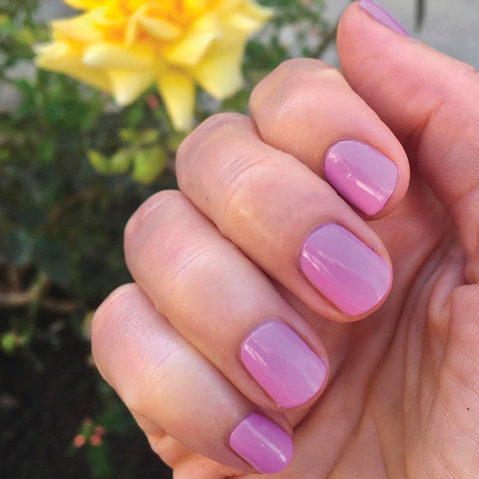 Hand with nails painted in Fierce & Loving lilac gel polish showing a vibrant, long-lasting manicure by Olive and June