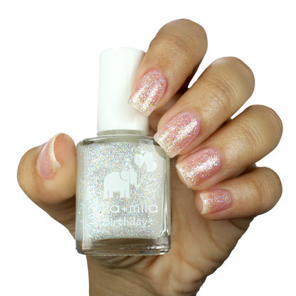 First Birthday iridescent glitter nail polish manicure on a light skin tone with the bottle