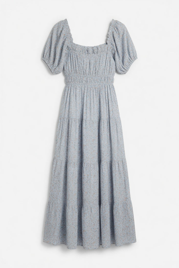 A light blue smocked dress with puff sleeves, a square neckline, and a tiered skirt, shown against a plain white background.