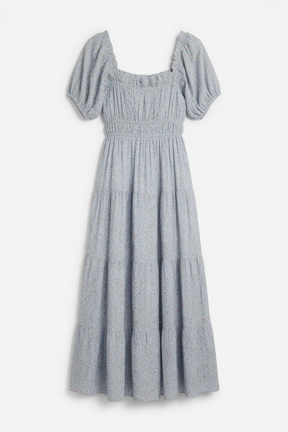 A light blue smocked dress with puff sleeves, a square neckline, and a tiered skirt, shown against a plain white background.