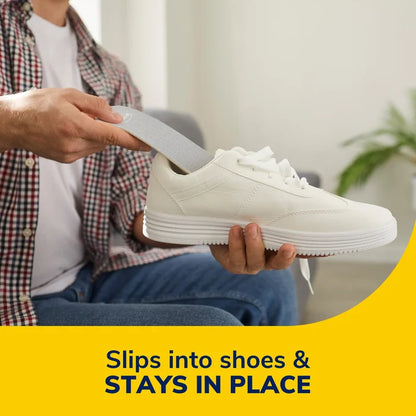 Hand sliding a gray sockless cushioning insole into a white sneaker