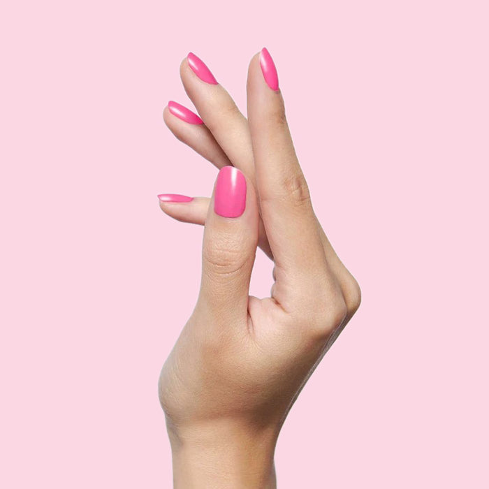 Hand with nails painted Grateful & Kind pure pink gel polish for a fresh and long-lasting at-home manicure by Olive and June
