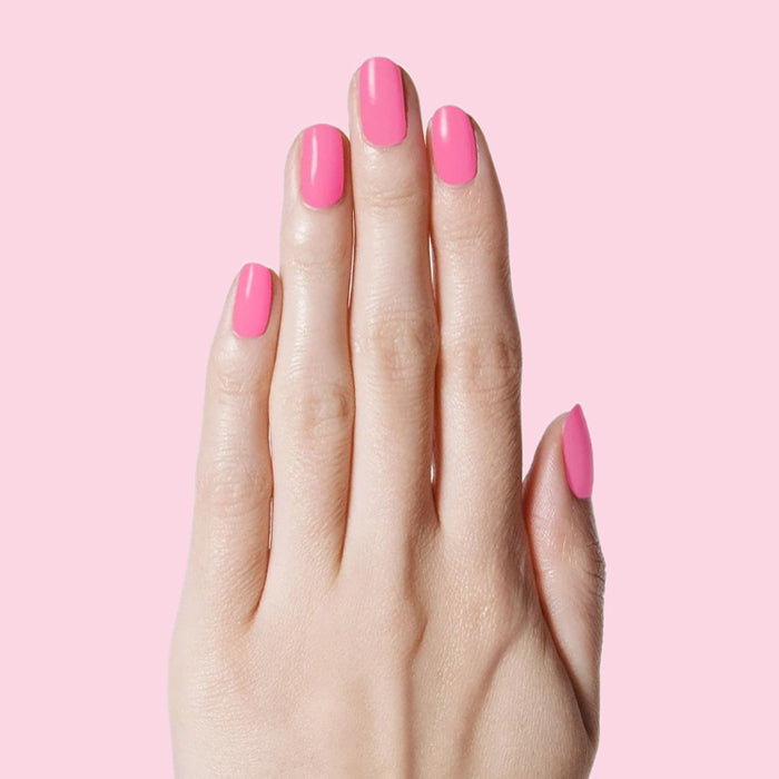Hand with nails painted Grateful & Kind pure pink gel polish for a smooth and long-lasting at-home manicure by Olive and June