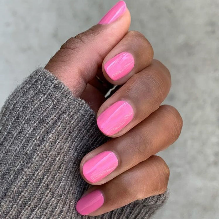 Close-up of hand with nails painted Grateful & Kind pure pink gel polish for a long-lasting manicure by Olive and June
