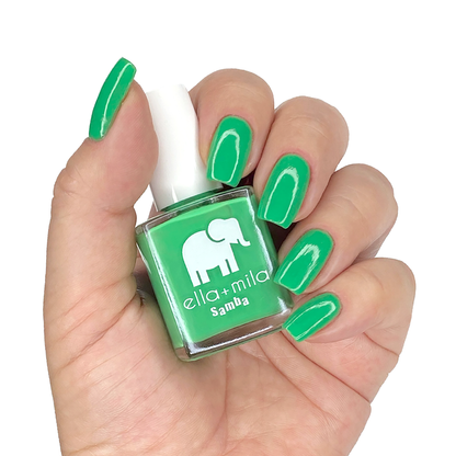 Green with Frenzy jade green nail polish on a medium skin tone, hand holding the bottle