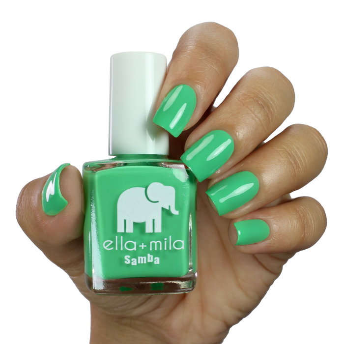 Green with Frenzy minty jade green nail polish on a deep skin tone, hand holding the bottle