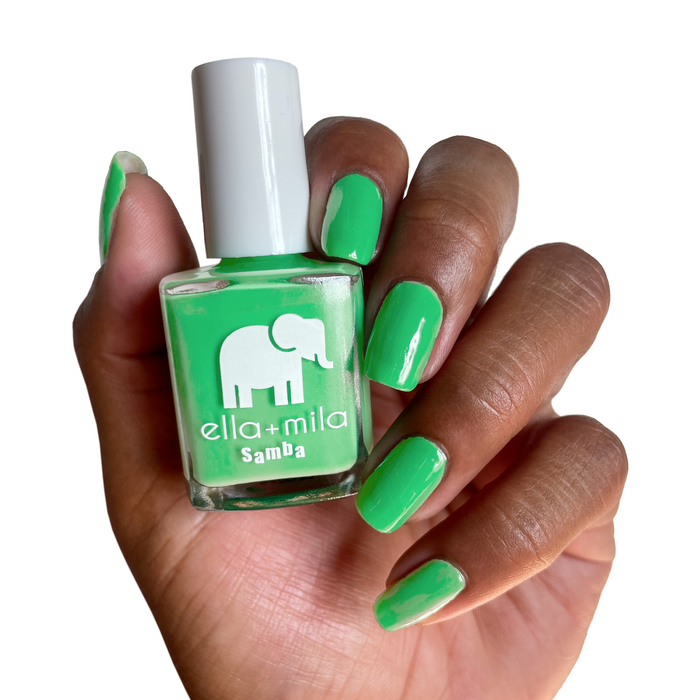 Green with Frenzy jade green nail polish on a deep skin tone, holding the bottle