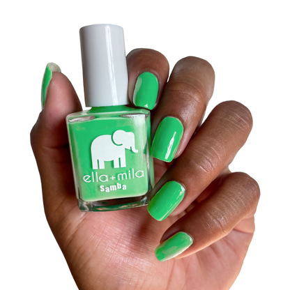 Green with Frenzy jade green nail polish on a deep skin tone, holding the bottle
