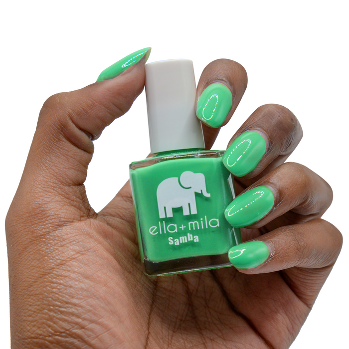 Green with Frenzy jade green nail polish on a deep skin tone, hand holding the bottle
