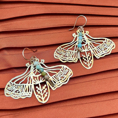 Handmade Peppered Moth earrings by Fluff Hardware showing detailed black and white moth design on silver hooks.