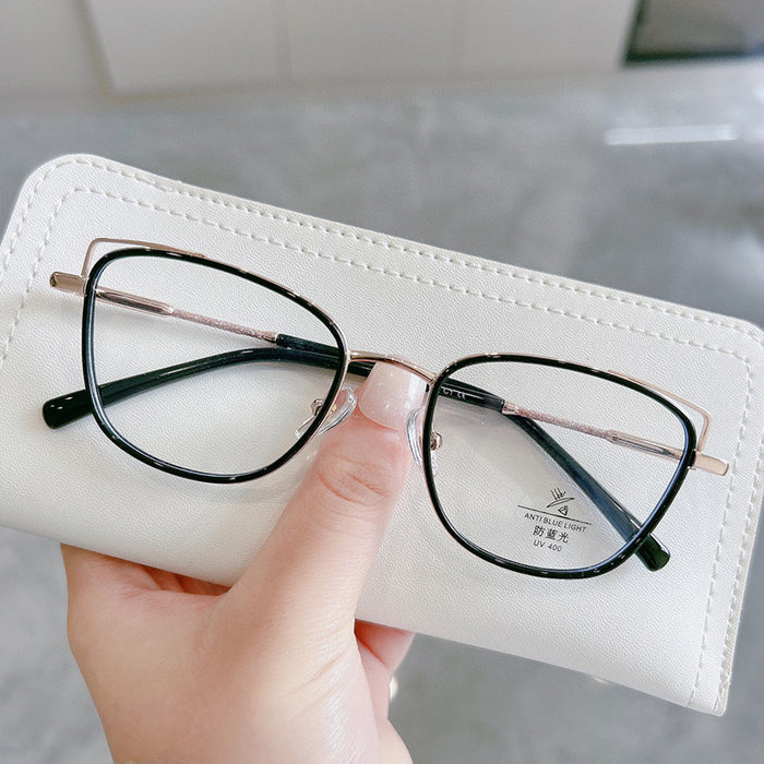 A hand holds EyeCandys Kaylee Cat Eye eyeglasses, featuring black rims with gold accents, resting on a white case; a UV protection label is seen on one lens.