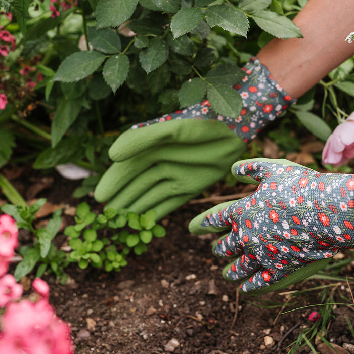 Gardening gloves with floral pattern worn by a person in a garden setting