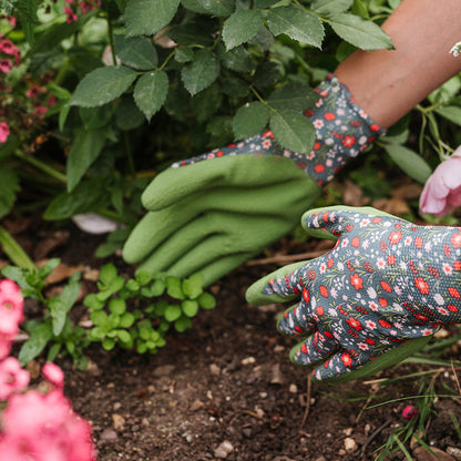 Gardening gloves with floral pattern worn by a person in a garden setting