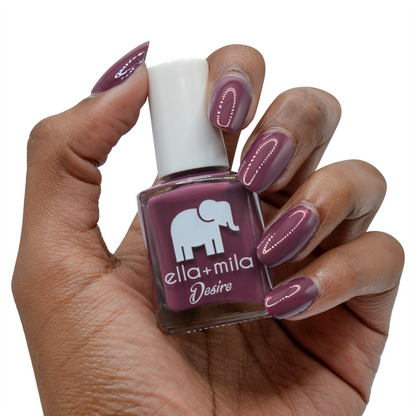 La Vie en Rose dark berry nail polish on a deep skin tone, hand holding the bottle
