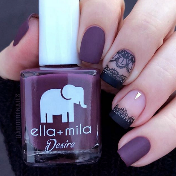 La Vie en Rose matte berry nail polish with a floral accent nail, holding the bottle