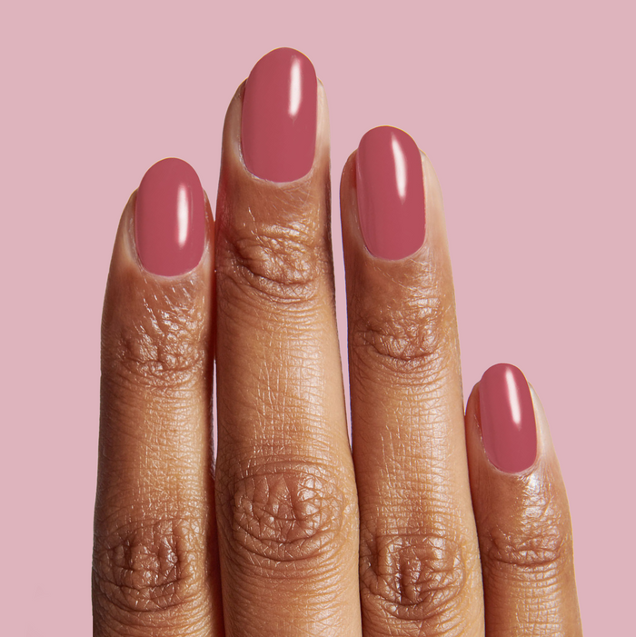 Hand with nails painted in LD nail polish, showing a rosy pinky rosewood shade for a polished manicure look