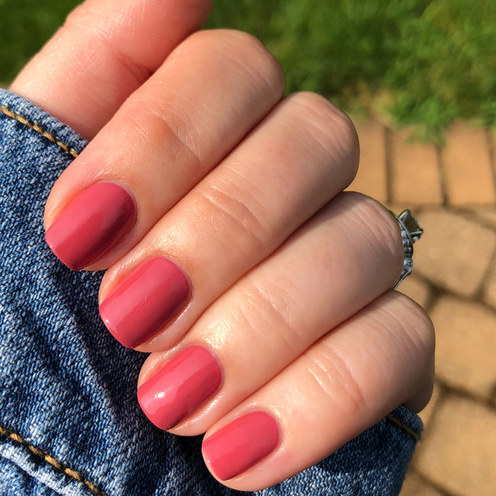 Hand with nails painted in LD rosy pinky rosewood shade for a polished and versatile at-home manicure look