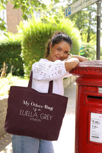 Female model wearing Luella Cherry Canvas Shopper with printed white text details over her shoulder with two shoulder straps
