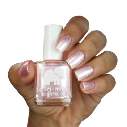 My Fantasy pearl pink nail polish on a medium skin tone, hand holding the bottle