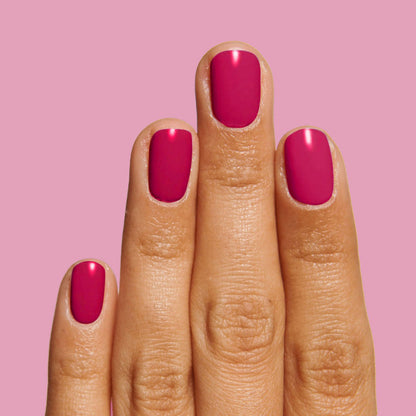 Hand with nails painted in rich jewel-toned red polish using Nailfie Time for a smooth, long-lasting mani