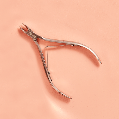 Stainless steel cuticle nipper on a peach background