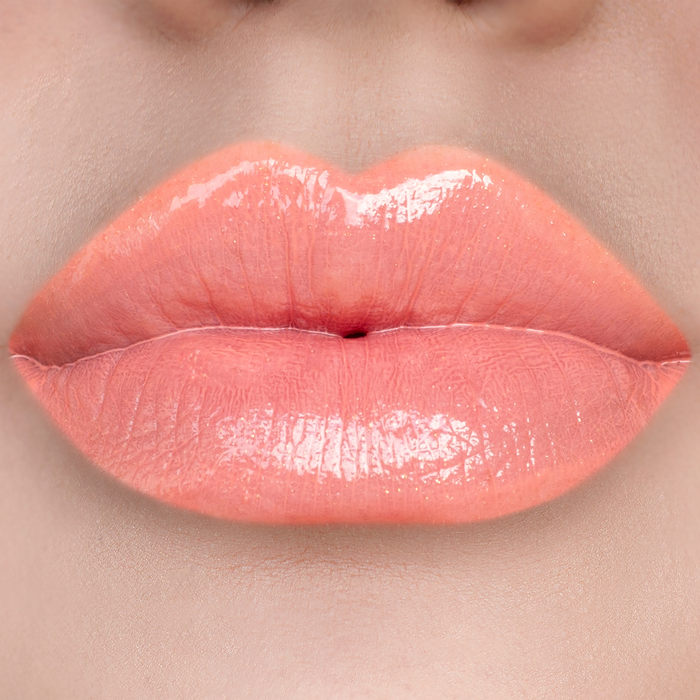 No More Games peach coral lip gloss on lips, light skin tone